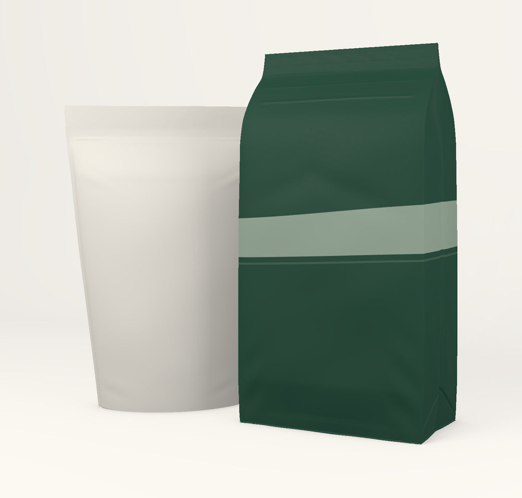 Forest-green flat-bottom pouch beside a smaller ivory stand-up pouch.